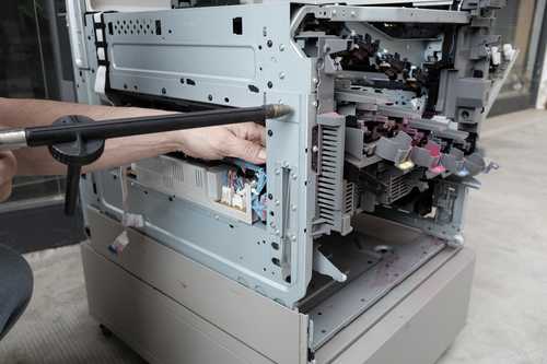 Engineer performing maintenance on a printer